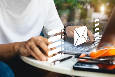 Hands at computer with graphic of email notification